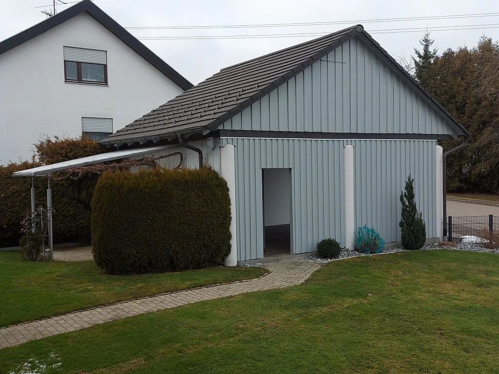 Fahrräder und Auto auf einem Hof vor einem Haus